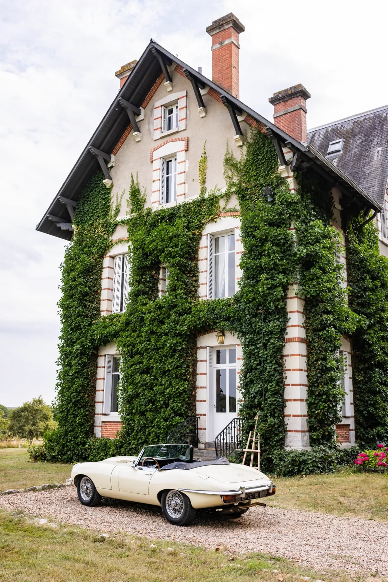 Demeure de caractère recouverte de lierre avec une voiture de collection, dans un parc de Sologne